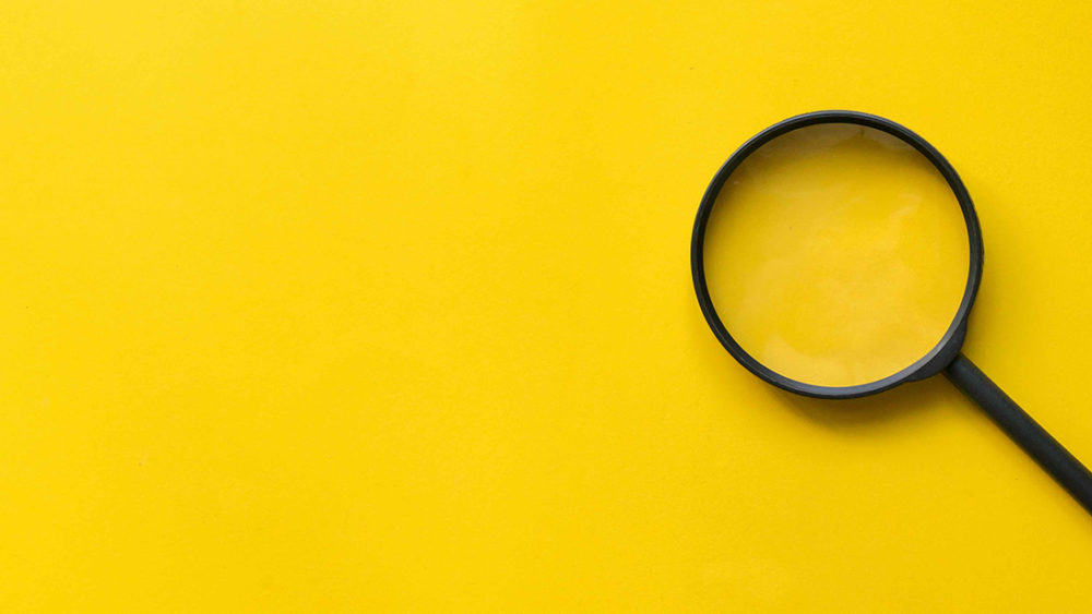 stock art with yellow background and black magnifying glass to the right