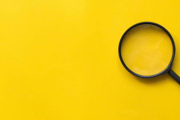 stock art with yellow background and black magnifying glass to the right