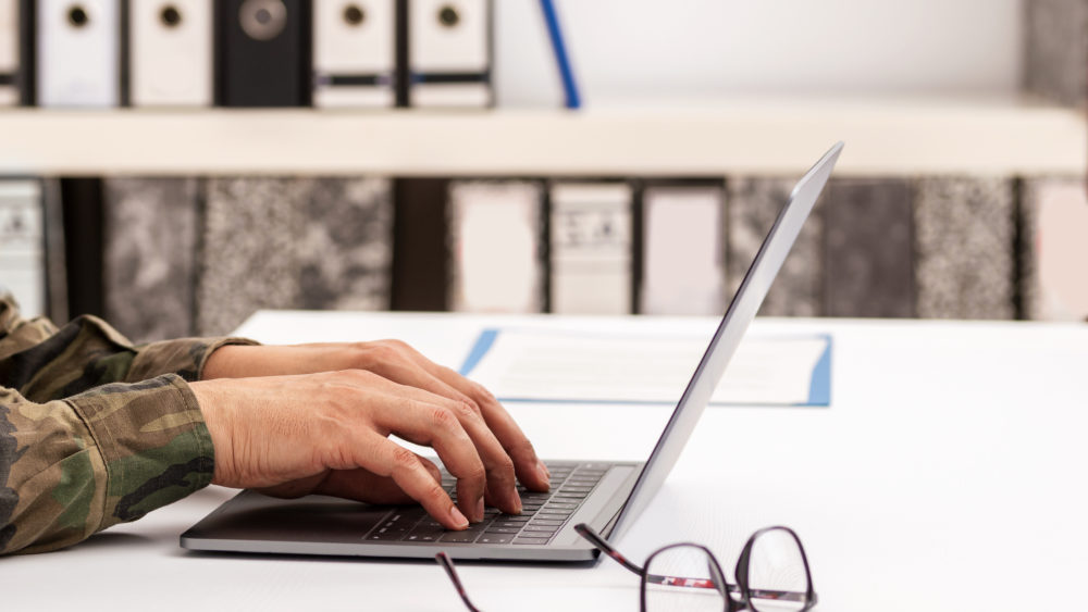 Close-up shot of a unrecognizable business person typing on a laptop keyboard