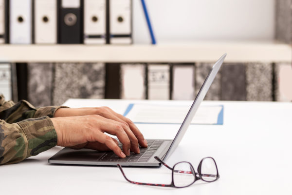 Close-up shot of a unrecognizable business person typing on a laptop keyboard